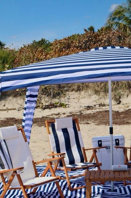 Blue striped beach umbrella and chair arrangement